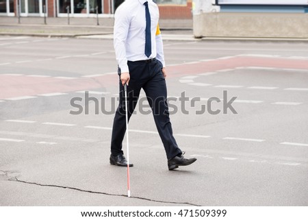 Blind Person With White Stick Walking On Street