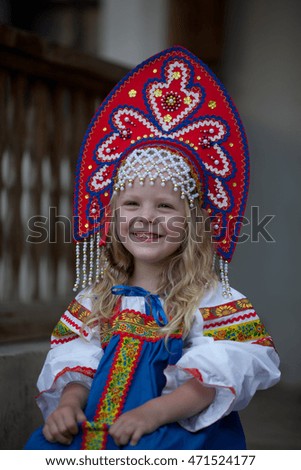 Little girl in the national costume walks through the territory of the Monastery