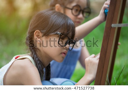 Happy Asian student girls writing on the blackboard together