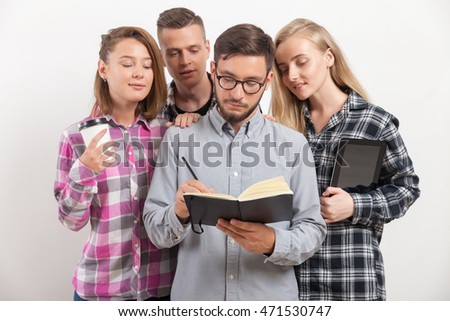 Man in glasses writing in his notebook while his coworkers look at his notes. Concept of brainstorming
