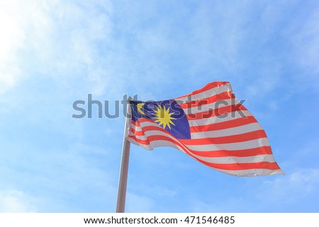 Malaysian national flag on a pole against blue sky