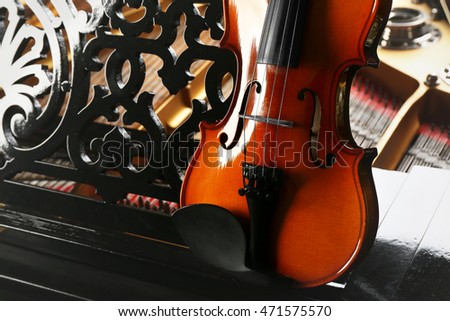 Violin lying on piano, close up