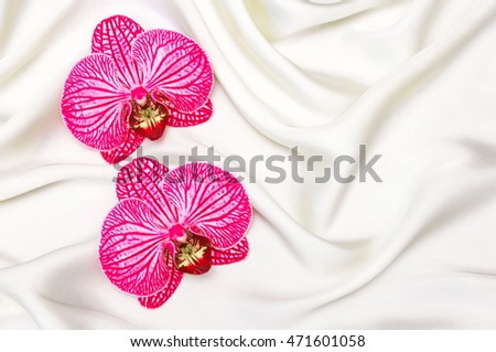 Pink  Orchid on white silk, orchids on the background of silk, soft focus