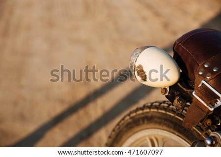 Close-up view on retro motorcycle headlights on the desert background