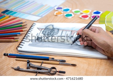 Designers hand drawing house illustration on notebook with office equipment / business & back to school concept
