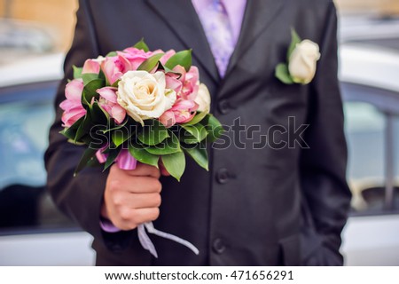 Bouquet in the hands of a man in a suit