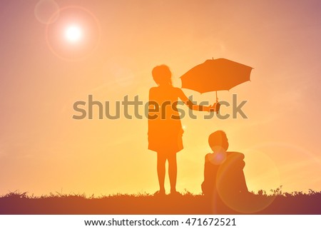 Silhouette children with umbrella on sunset