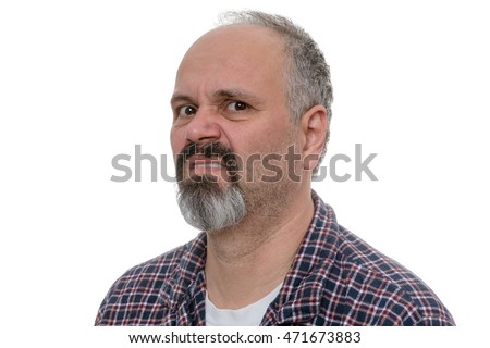 Angry balding man with beard sneers at the camera while wearing plaid shirt Royalty-Free Stock Photo #471673883