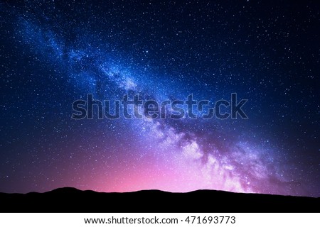 Milky Way and pink light at mountains. Night colorful landscape. Starry sky with hills at summer. Beautiful Universe. Space background with galaxy. Travel background Royalty-Free Stock Photo #471693773