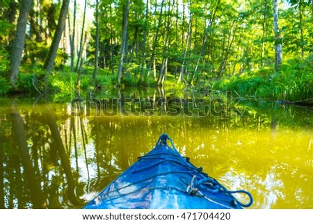 Kayaking by wild river in forest in poland (Omulew river near Nidzica). Summer recreation.