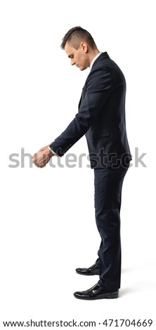 Side view of a businessman looking downwards and holding something isolated on white background. Business staff. Office clothes. Body language.