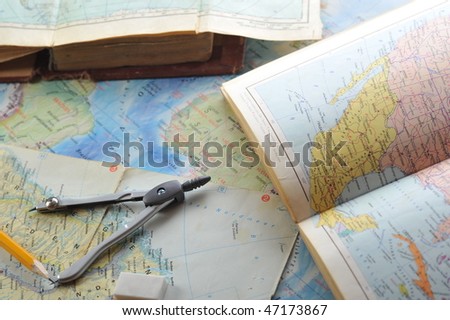  opened old atlas book on  map and pencil