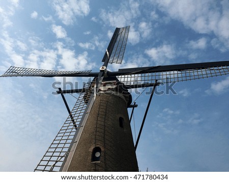 Windmill close up with a blue sky with clouds background on a sunny day. Space for text.