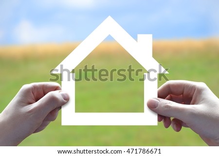 House insurance concept - human hands holding white paper-cut.