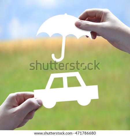 Car protection concept - human hands holding white paper-cut.