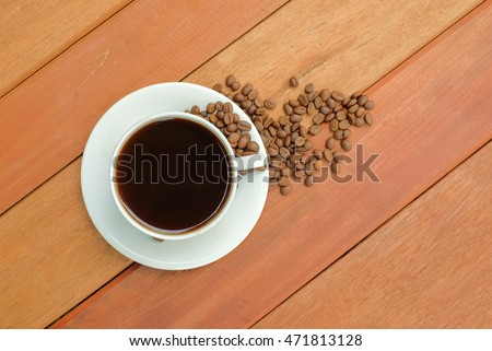 a selective focus picture of a cup of coffee on wooden table