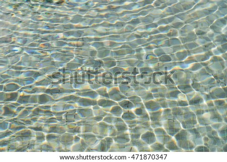 The ripples wave on the surface of the pool with the sunlight shining down.