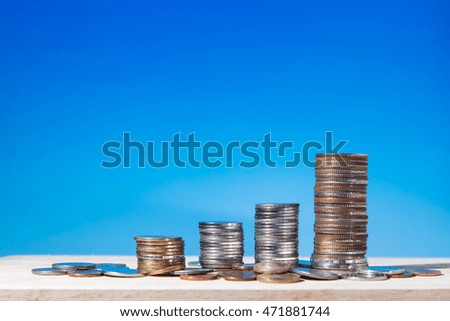 money coin like stack growing business on blue sky background. Finance and Money concept,Hope of investor 
