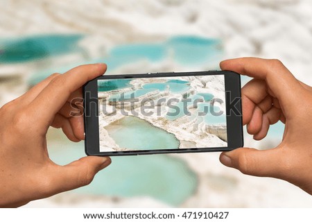 Woman hands with mobile cell phone to take a photo of mineral springs in Turkey, Pamukkale