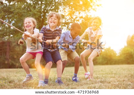 Kids playing tug of war at the park Royalty-Free Stock Photo #471936968