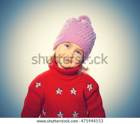 Little Funny girl in cap and red sweater. Isolated on  background