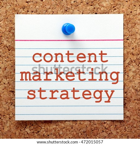 The words Content Marketing Strategy in red text on a note card pinned to a cork notice board as a reminder