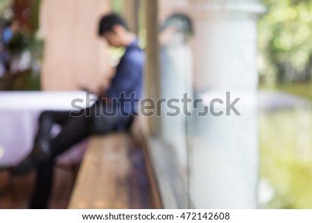 Abstract Blurred image of asian man use smartphone