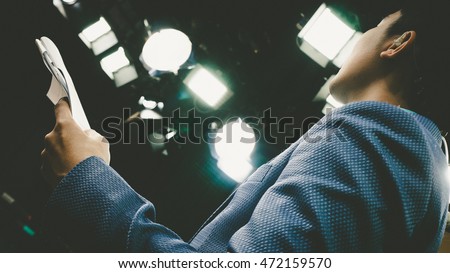 Television presenter review scripts in studio