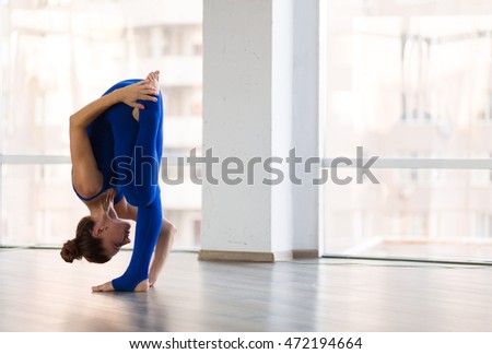 Young beautiful woman practicing yoga in a studio