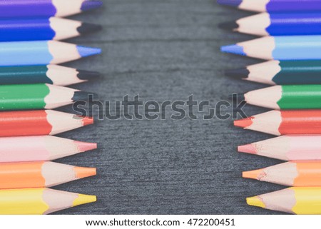 Colored drawing pencils on the wooden grey table. Colorful pencils in a variety of colors. Back to school concept. Toned picture.
