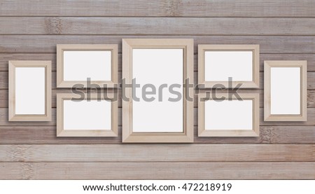 Collage of seven blank wooden photo frames on wooden panels wall. Royalty-Free Stock Photo #472218919
