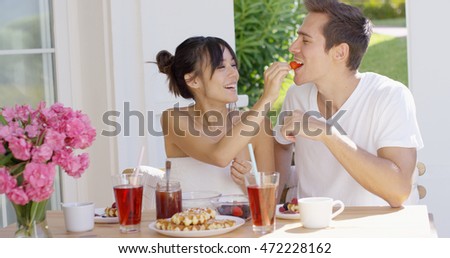 Couple feeding each other at breakfast
