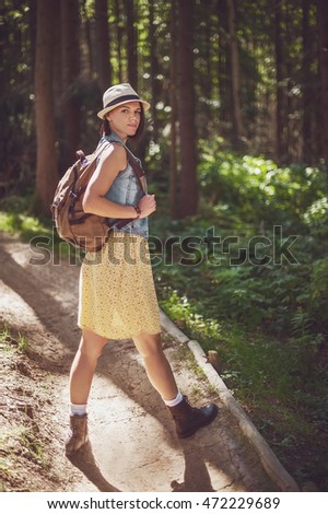 beautiful girl  dressed in country style walking in the deep forest. vintage picture