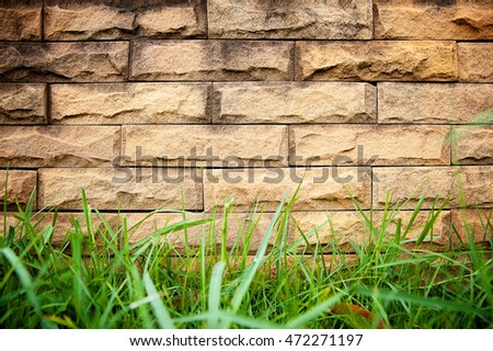 Background bricks and grass green .