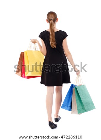back view of going  woman  with shopping bags . beautiful girl in motion.  backside view of person.  Rear view people collection. Isolated over white background. Blonde in a short black dress shopping
