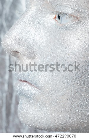 Beautiful, amazing portrait of woman. Unreal make up like a space. Closeup shooting in studio with silver background. Emotion, posing of model. silver glitter.