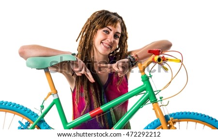 Girl with dreadlocks on colorful bike