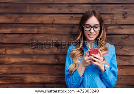 Beautiful young hipster woman using smart phone. Royalty-Free Stock Photo #472303240