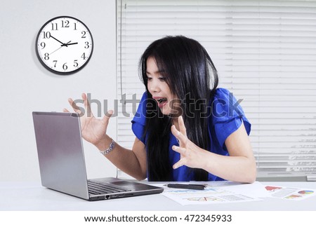 Picture of a young businesswoman looks surprised while looking at laptop computer in the office