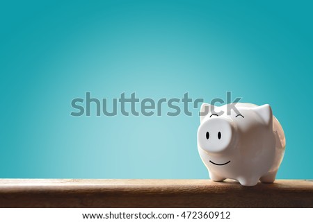 Piggy bank on blue background. Soft focus Royalty-Free Stock Photo #472360912