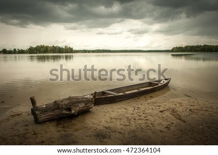 Lake view with boat. The wood boat on lake at sunset. Concept of loneliness, lacking direction, no leadership, rudderless, floating, listless or generally adrift without a goal. stillness calms Royalty-Free Stock Photo #472364104