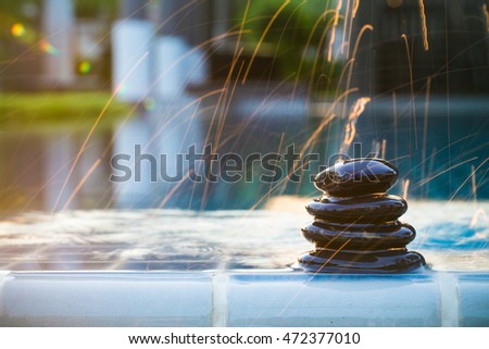 Spa background. Still life with water drops and zen black stone on serenity swimming pool