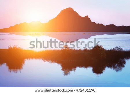  Amazing sunset behind mountains. Water reflection