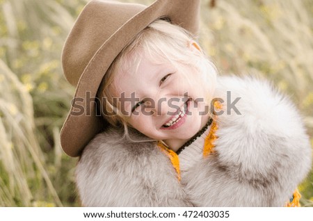 beautiful laughing girl with cowboy hat in autumn field portrait 