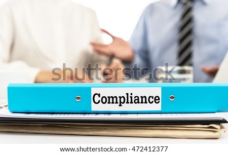 Compliance document folder on desk in meeting room with business team. Royalty-Free Stock Photo #472412377