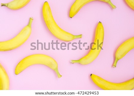 Fresh yellow bananas over pink background pattern, top view Royalty-Free Stock Photo #472429453