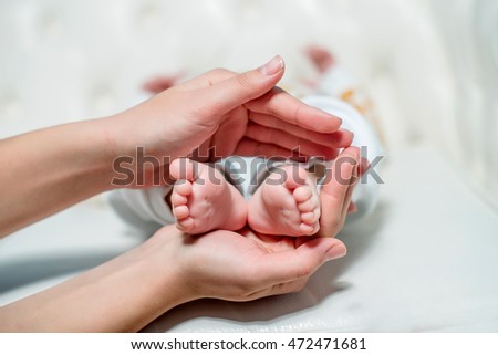 Mom holding baby feet on a white background