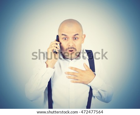 Bald mustachioed man talking on the phone. Emotions.