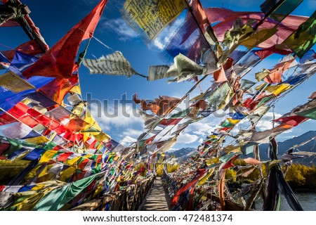 Colourful Buddhist prayer flags on a bridge above Indus river in the Himalayan mountain, Leh, Ladakh, India Royalty-Free Stock Photo #472481374