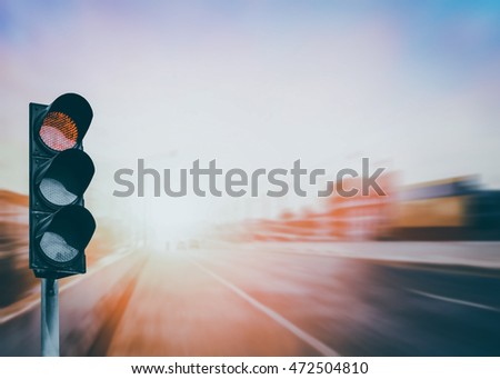 Red traffic light on the expressway asphalt road with car in a city landscape at sunrise. light sign for car stop and speed reduction. Dangerous,warning signal,semaphore. Driving on a Highway.